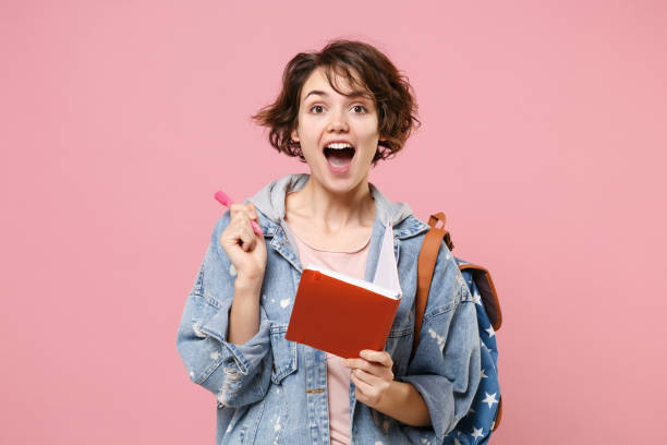 A student holding a book and looking excited to practice tips on how to become a top student